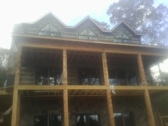 Dormers and porch framing on a large log home under construction in Hopewell
