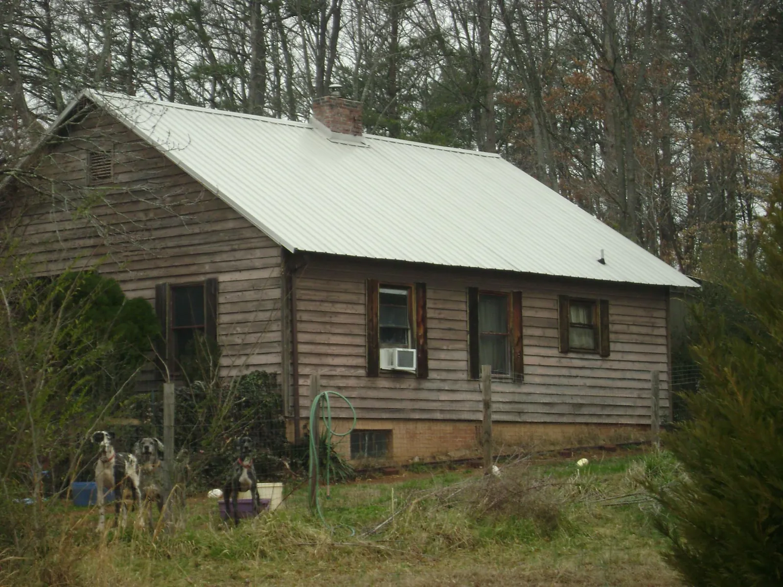 White metal roof on an old wood sided farmhouse, from a Metal Roof Installation job in Hopewell
